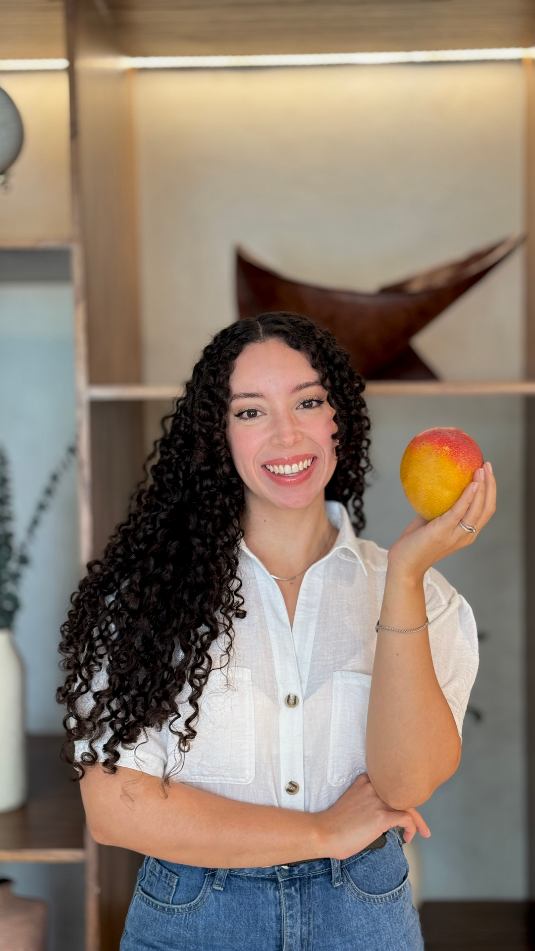 Lic. Megan Maldonado, nutricionista, sosteniendo un mango